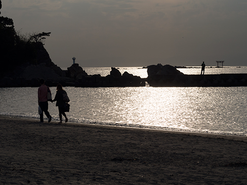 若いカップル、夕方の海の高画質画像